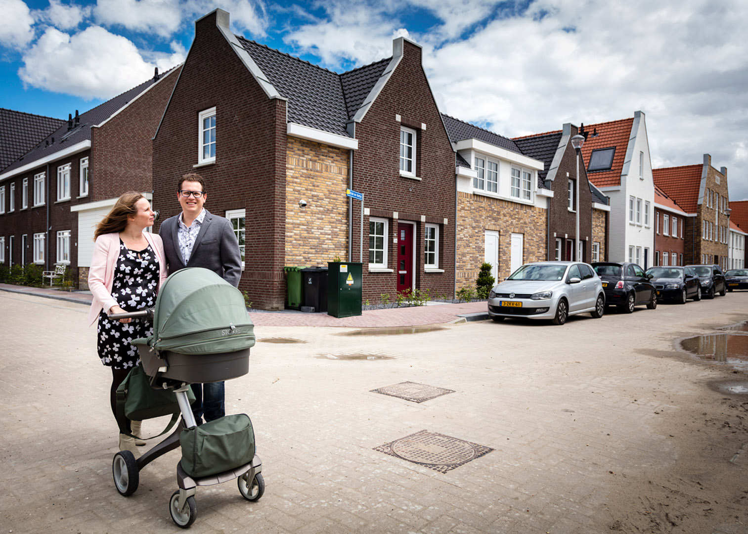 Een man en vrouw duwen een kinderwagen met een baby erin.